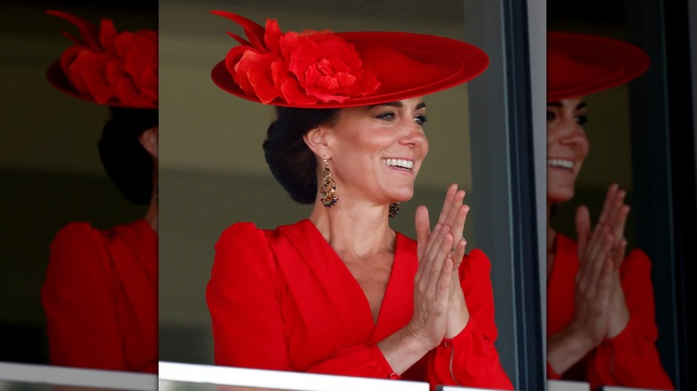 Princess Catherine clapping in a red hat and dress