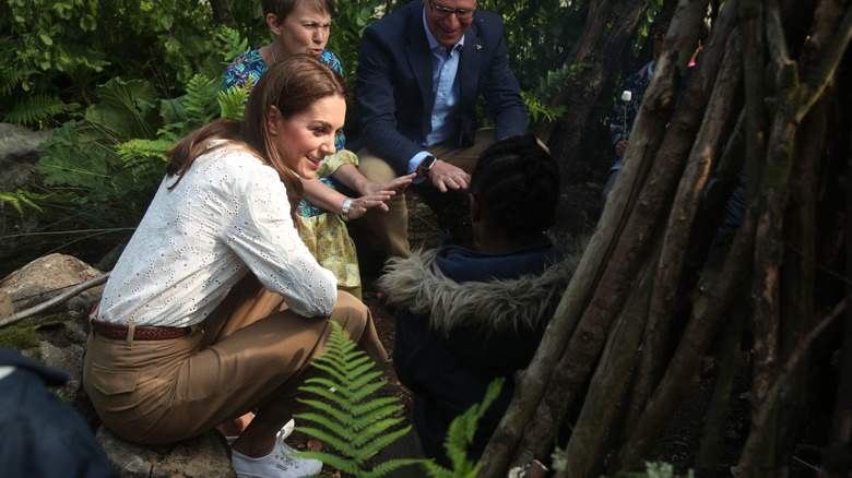 Princess Catherine outside sitting on log