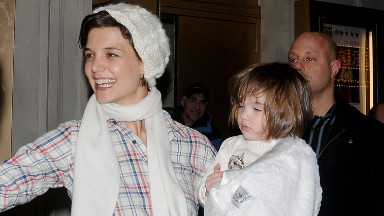 Katie Holmes signing autographs while holding Suri Cruise