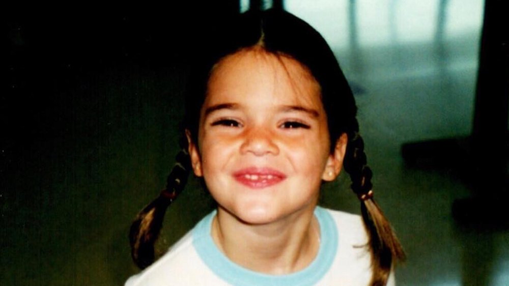 Kendall Jenner as a girl, wearing pigtails and smiling