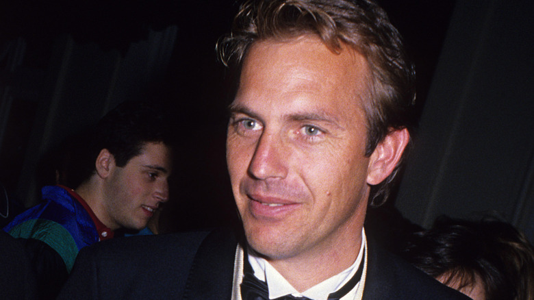 Kevin Costner talking to someone at an event