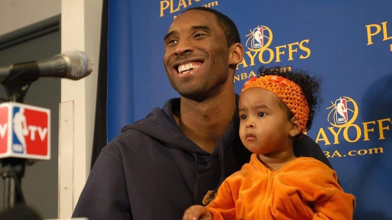 Kobe Bryant smiling with baby Natalia Bryant in his arms