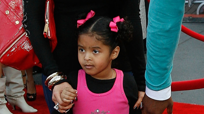 Young Natalia Bryant clutching her parents' hands 