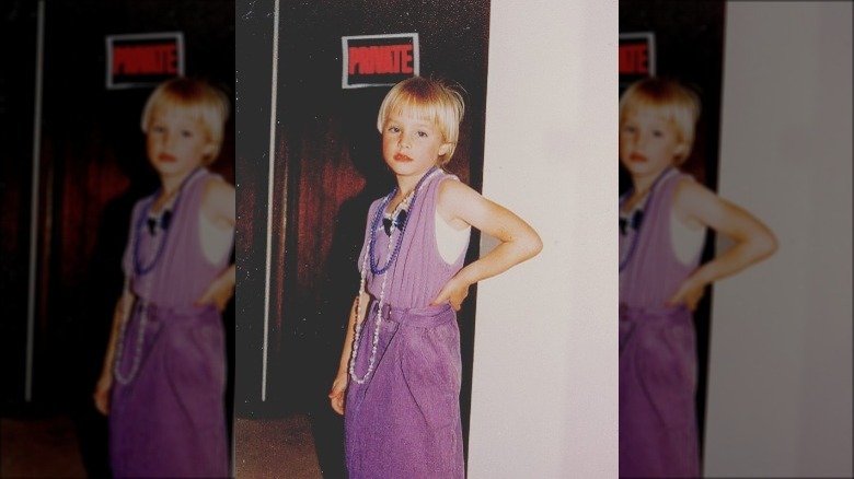 Kristen Bell as a young girl in a purple dress