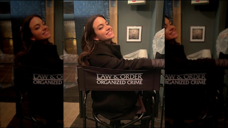 Lauren LaVera sitting in a Law & Order: Organized Crime directors chair