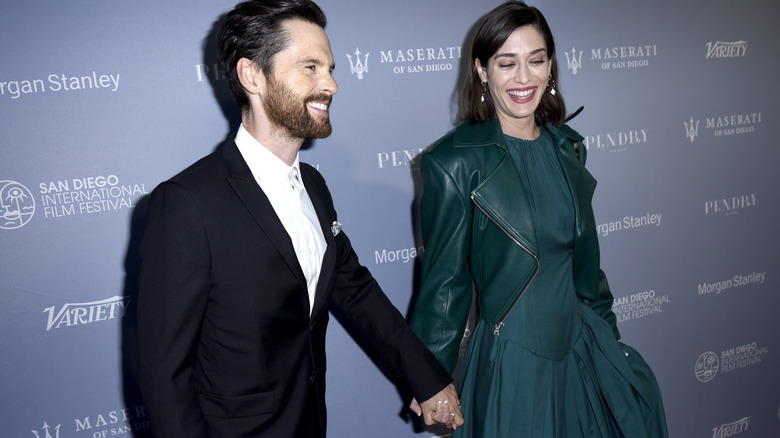 Lizzy Caplan and Tom Riley holding hands