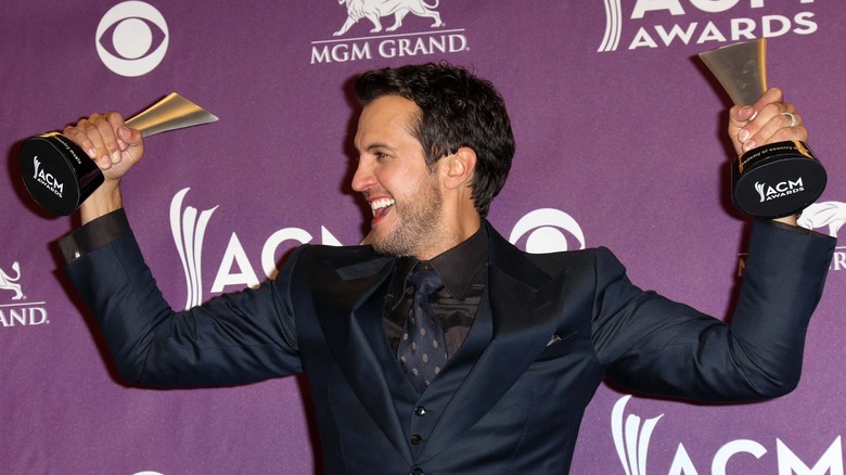 Luke Bryan holding awards