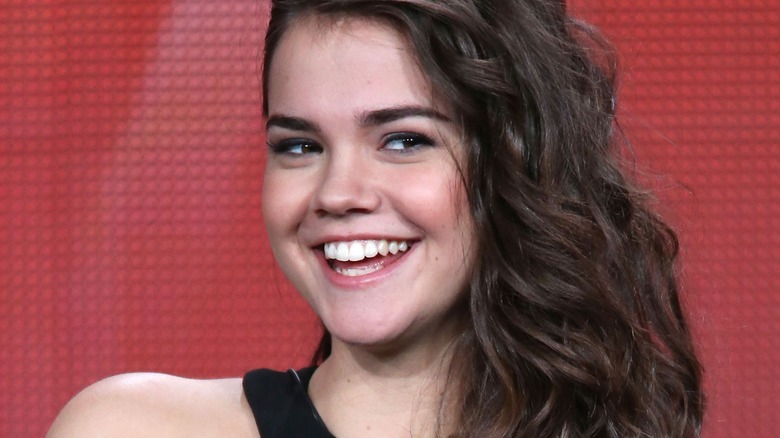 Maia Mitchell at an early Fosters press conference, red background