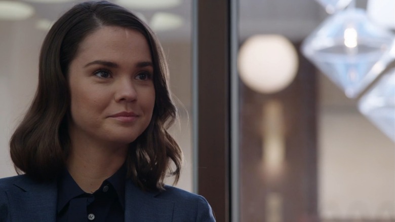 Maia Mitchell smiling in front of a window on Good Trouble