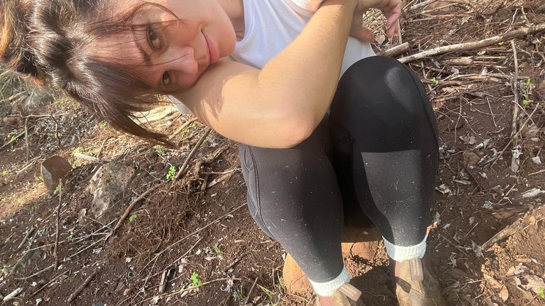 Maia Mitchell sitting on the ground in boots