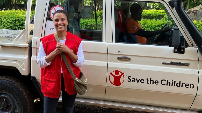 Marilee Fiebig Holmes posing with Save the Children truck