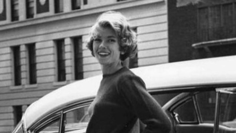 Martha Stewart as a young woman next to a car