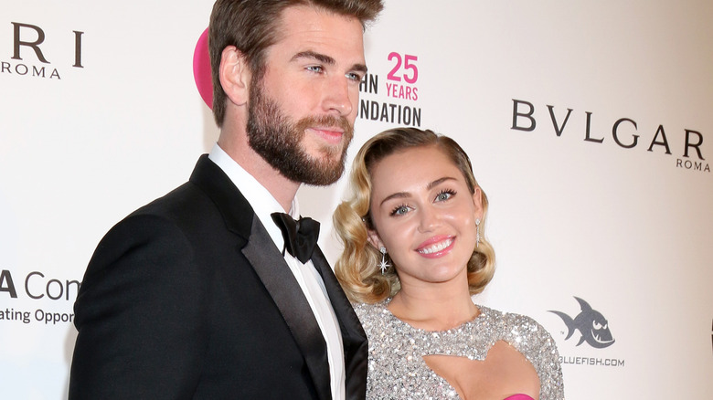 Liam Hemsworth and Miley Cyrus posing