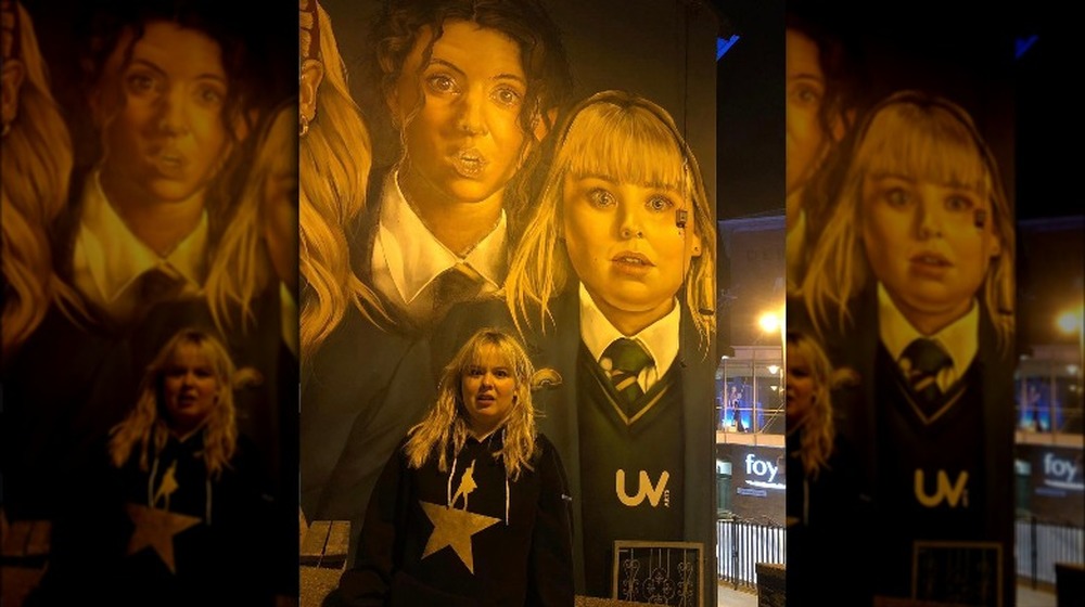 Nicola Coughlan in front of a mural of Derry Girls