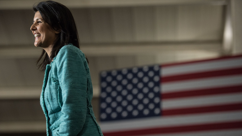 Nikki Haley smiling in front of an American flag