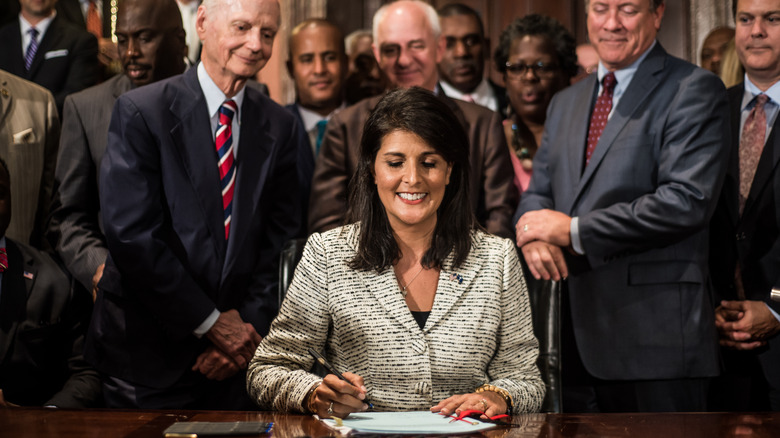 Nikki Haley smiling while signing a bill