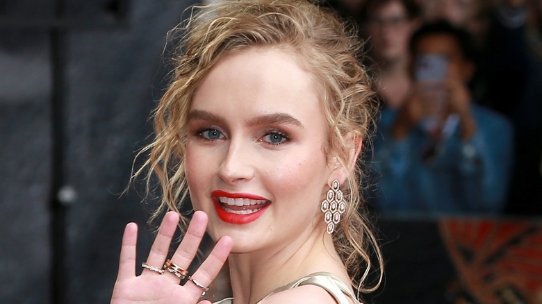 Olivia DeJonge waves at a premiere