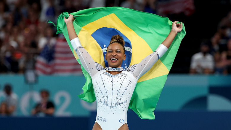 Rebeca Andrade smiles with Brazilian flag 