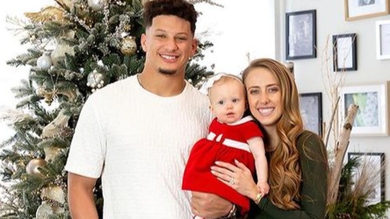 Patrick Mahomes, Brittany Matthews, and their daughter smiling 