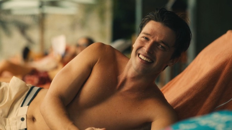 Patrick Schwarzenegger as Saxon Ratliff shirtless on a beach chair