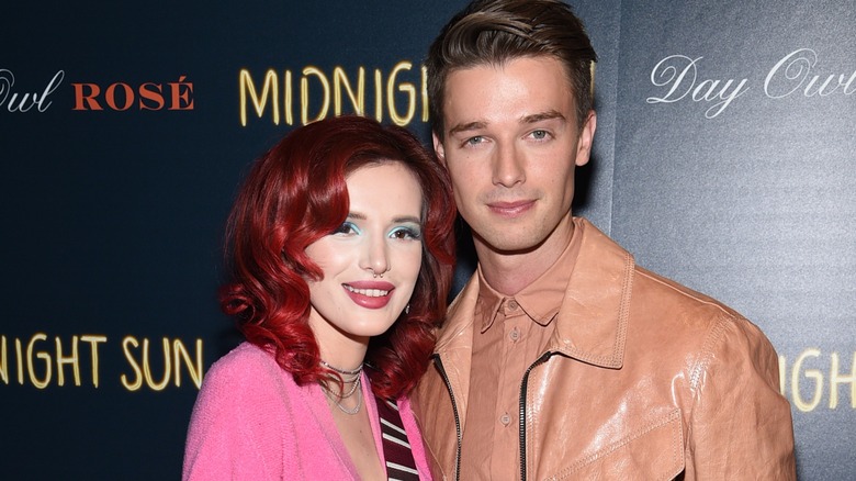 Bella Thorne and Patrick Schwarzenegger in pink jackets on a Midnight Sun step-and-repeat