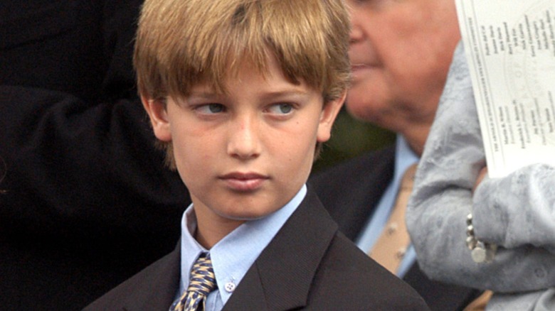 A young Patrick Schwarzenegger in a suit, looking to the right