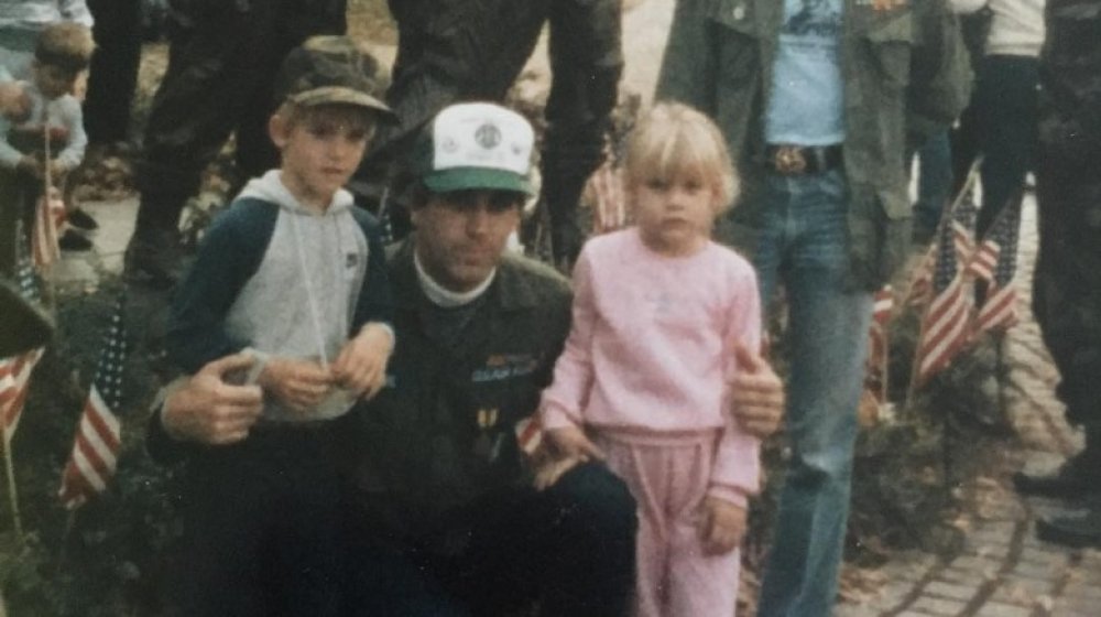 Pink as a child at a parade with her father and brother