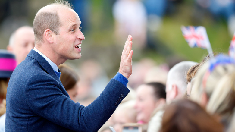 Prince William waving to a crowd