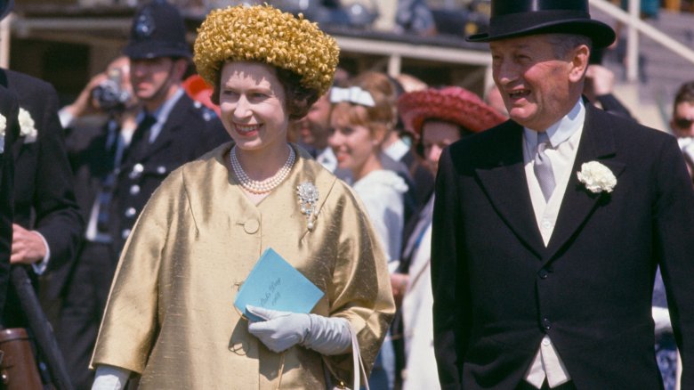 Queen Elizabeth II sporting bold fashion with gold hat and jacket