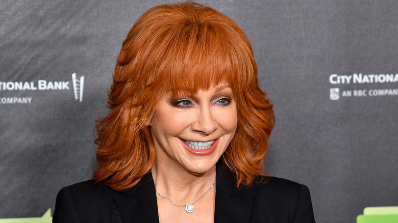 Reba McEntire smiling in a black jacket 