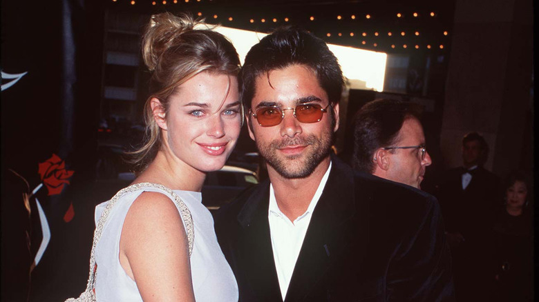 Rebecca Romijn posing with John Stamos