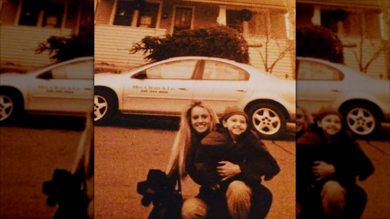 Nicole Curtis posing with her son in front of a house