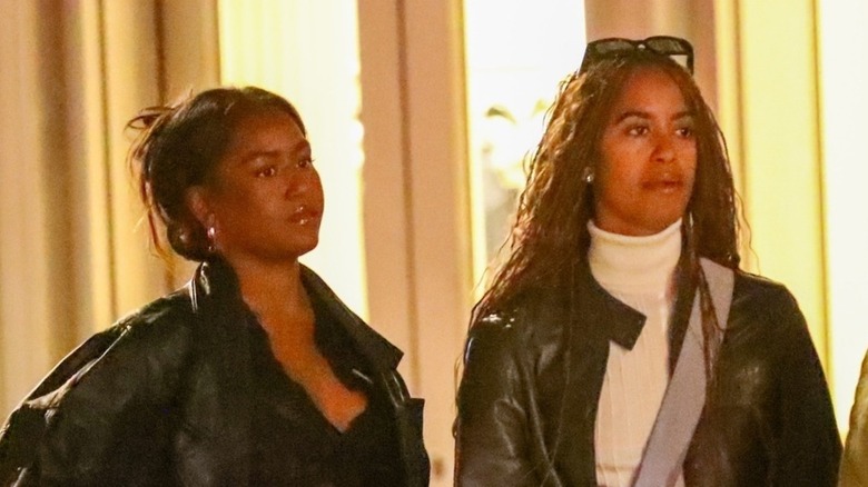 Sasha and Malia Obama looking off to the side