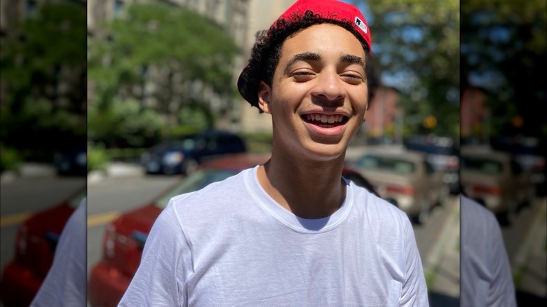 Smiling Julez Smith wearing a red cap and white T-shirt