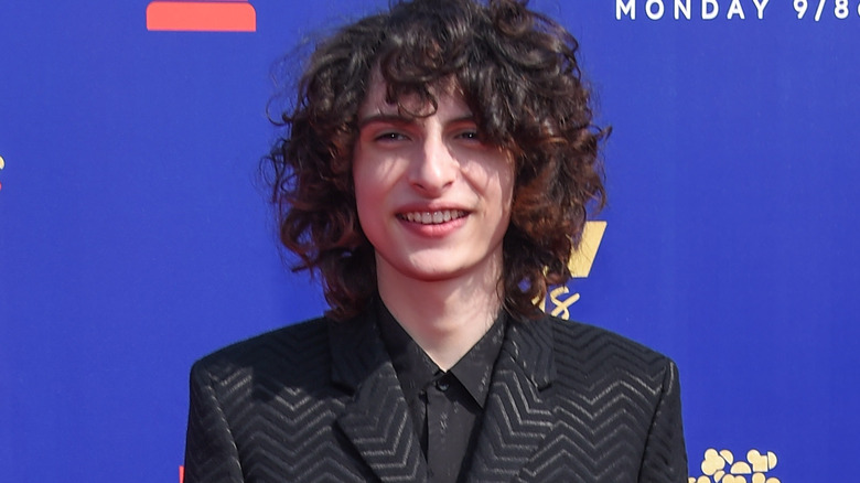 Finn Wolfhard smiling in suit