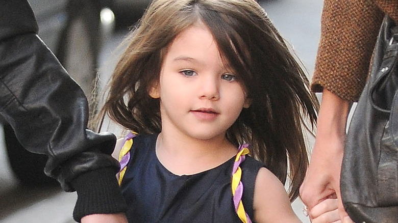 Suri Cruise long hair holding hands