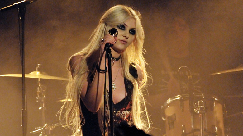 Taylor Momsen clutching a mic stand 