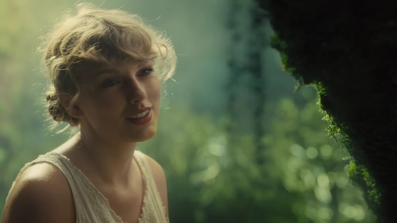 Taylor Swift smiling in the woods