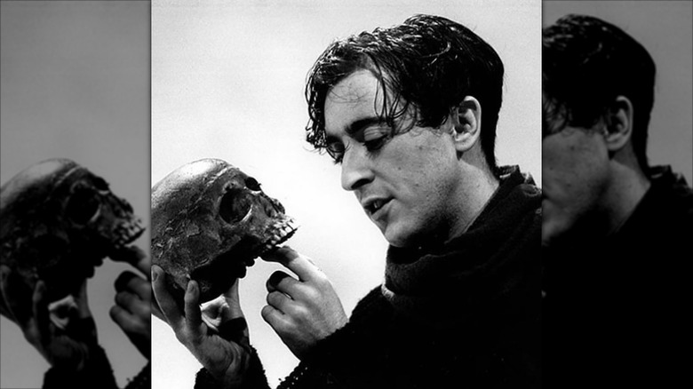 A young Alan Cumming holding a skull, performing Hamlet on stage in 1993