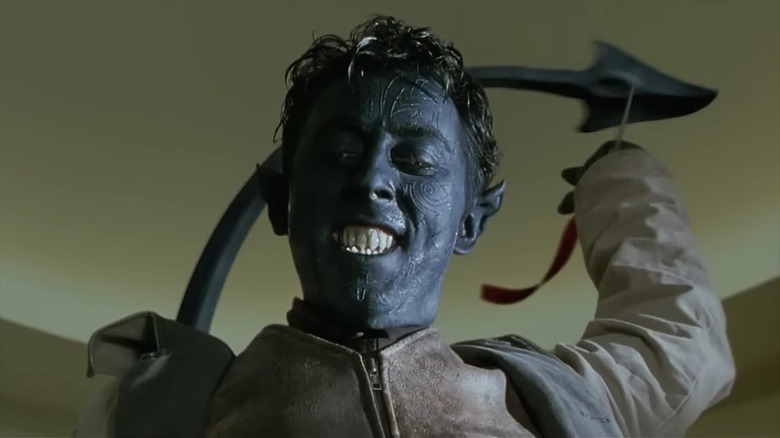 Alan Cumming as Nightcrawler, his skin painted blue, his tail above his head