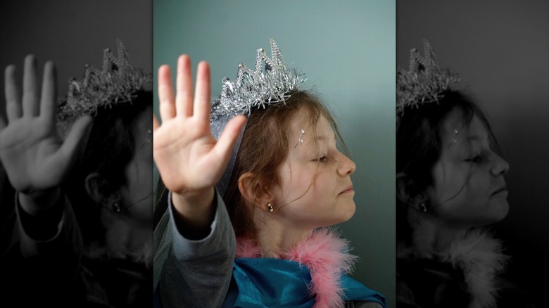 Thomasin McKenzie as a child raising her hand