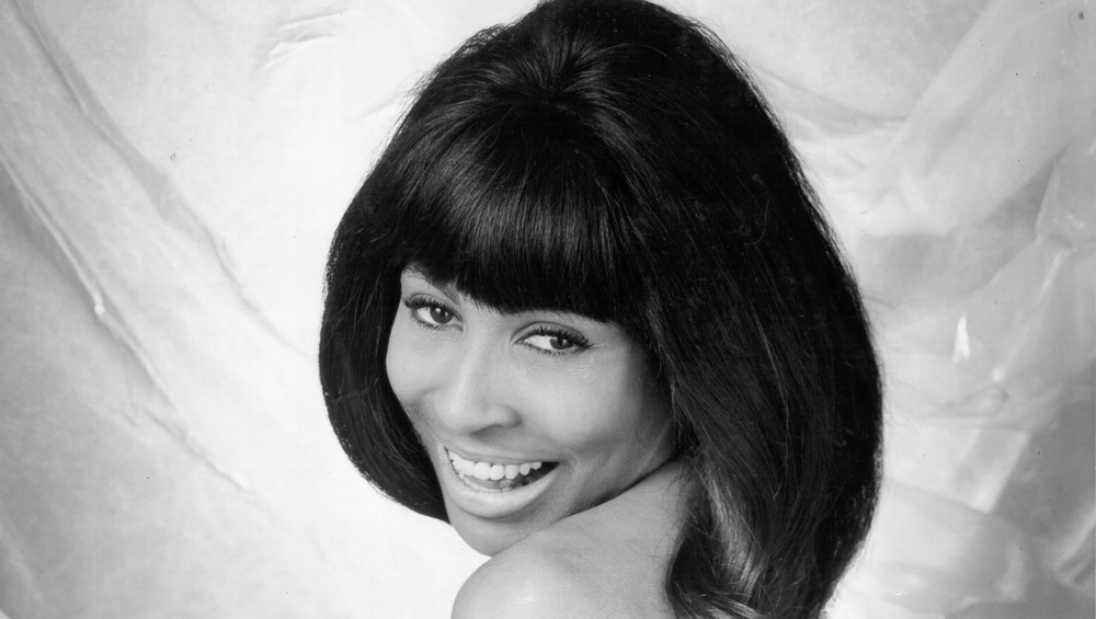 Tina Turner smiling over shoulder