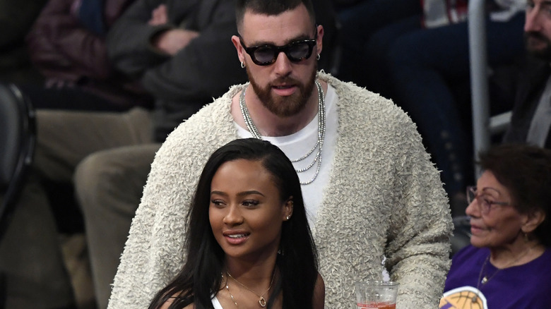 Travis Kelce and Kayla Nicole sitting at a basketball game