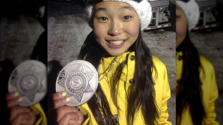 Chloe Kim holding medal, smiling