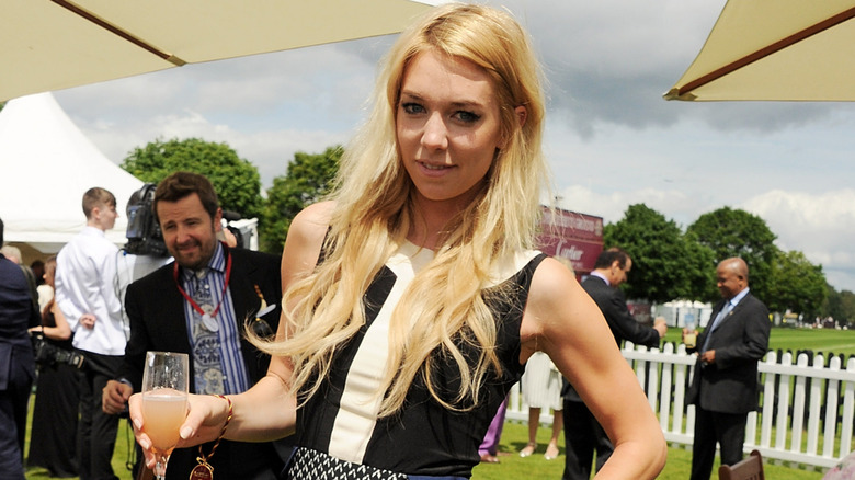 Vanessa Kirby posing at outdoor event holding cocktail