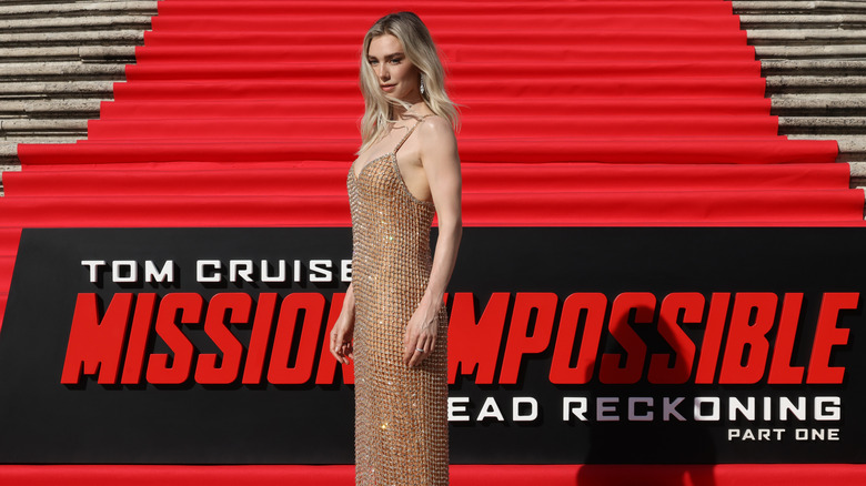 Vanessa Kirby posing in front of "Mission Impossible" sign on red carpet steps