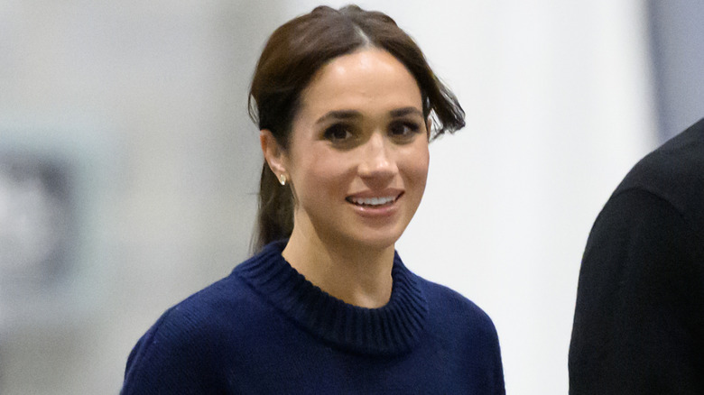 Meghan Markle smiling in a blue sweater while attending a wheelchair basketball game at the 2025 Invictus Games at the Vancouver Convention Centre on February 09, 2025 in Vancouver, British Columbi