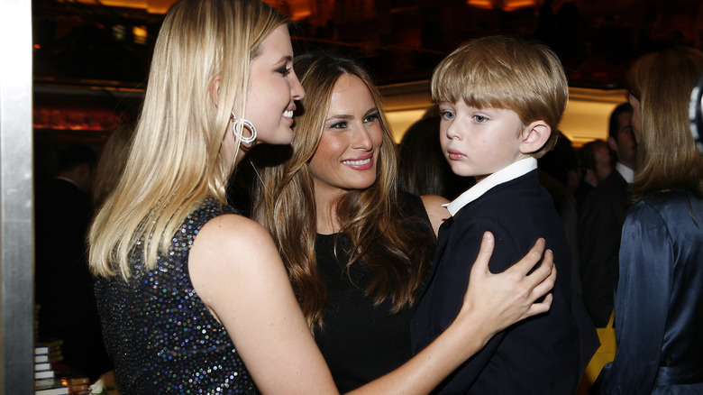 Ivanka touches Barron on the shoulder, Barron being held by Melania Trump