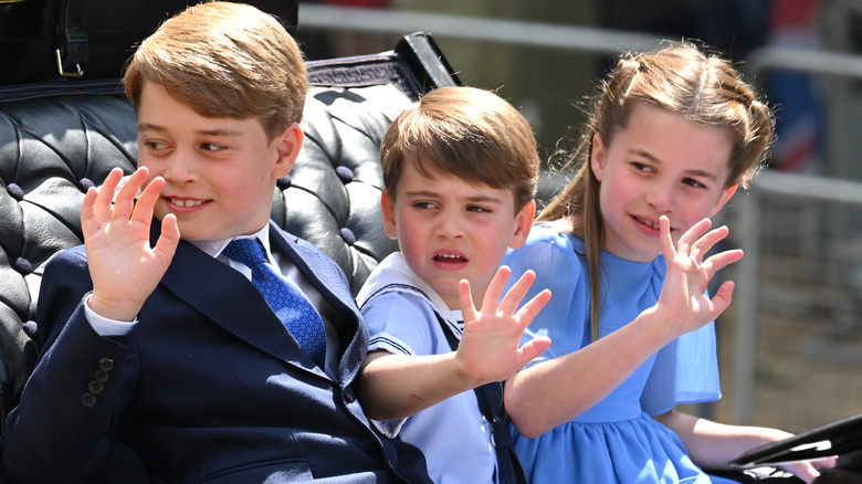 Prince George, Prince Louis, and Prince Charlotte waving in carriage