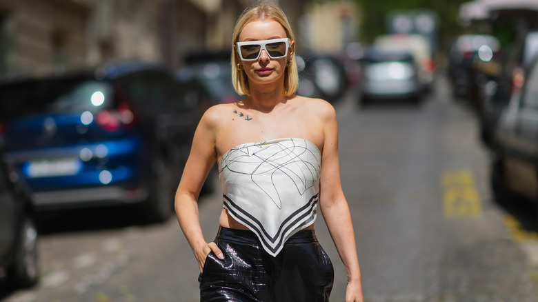 Woman wearing scarf top walking down street